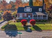 Nestled in the sought-after Orchard Hill neighborhood of Greenburgh, Westchester County, this enchanting 1936 Brick Tudor-Style Colonial home blends classic elegance with modern comforts. Its curb appeal features meticulously manicured shrubs & vibrant plantings. The front entrance leads to a spacious open patio. A charming summer porch is perfect for morning coffees. Inside, the extra-large living room exudes warmth with a striking floor-to-ceiling stone wood-burning fireplace. Vaulted wood-beam ceilings enhance the ambiance, with French doors connecting to the summer porch. Adjacent, a primary bedroom offers a full ADA-compliant bathroom accessible from both the primary & second bedrooms. The EIK has a generous granite island, stainless appliances, door to 2nd porch. UL offers 2nd Primary Bdrm, 2 more Bdrms, Full bath. The LL includes a 2nd LR, 2nd Fireplace, Storage, Laundry space. 2 car garage with extra-long driveway. Updated electrical systems, alarm, eco-smart thermostat.