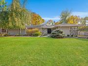 SPRAWLING UPDATED RANCH Set back from the road, this beautifully updated 4-bedroom ranch offers privacy and elegance. Enter through grand double doors into a bright hallway with marble floors, smart lighting, and skylights. The updated kitchen and spacious dining room are perfect for entertaining, while the cozy family room features limestone flooring and a wood fireplace. This home includes three full baths, built-in closets, two attics, a full-house generator, and an epoxy-finished garage. Outdoors, enjoy an Olympic-sized steel pool with new equipment, a bluestone patio with a built in BBQ, and lush greenery. A charming brick circle accents the driveway and entryway, while a powered two-story shed and a security system with four cameras add convenience and peace of mind. Move-in ready schedule your tour today!