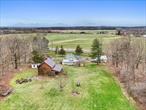 Whether you&rsquo;re an investor looking for a profitable opportunity or a remote worker seeking a peaceful home with ample outdoor space, this charming farmhouse ticks all the boxes.Step into a piece of history with this beautifully updated 1780s farmhouse, where the charm of country living meets the conveniences of modern life. Picture yourself enjoying breathtaking panoramic views of the Catskill Mountains and mesmerizing sunsets from the comfort of your own home. This property not only offers a serene retreat but also presents lucrative income potential.With 3 bedrooms and 2 full bathrooms, this farmhouse features multiple living areas, including a versatile room that can easily transform into a third bedroom or guest roomâ€”perfect for family gatherings or entertaining guests. Stay warm with the inviting fireplace or cozy up by the wood stove in the living room. The expansive eat-in kitchen is a chefâ€™s dream, equipped with generous counter space and ample cabinetry, giving you the room to create culinary masterpieces. The separate laundry room adds convenience to everyday living. Experience the great outdoors with three distinct spacesâ€”relax on the balcony off the primary ensuite bedroom, picnic on the side patio, or unwind on the full front porch, facing the expansive mountain views. Each space is designed for enjoyment and connection with nature.This property is ready for you to move in, with significant upgrades already completed. Enjoy peace of mind with a new propane boiler, an on-demand hot water heater, a state-of-the-art water treatment system, structural reinforcements, and an upgraded septic system. All thatâ€™s left is for you to choose your paint colors and personalize your space!The one-bedroom apartment adjacent to the detached garage offers additional living space or rental income. Recently upgraded with luxury vinyl plank flooring, new appliances, and updated kitchen and bathroom cabinetry, itâ€™s perfect for tenants seeking comfort and style.Explore the additional features that make this property truly unique: off-street parking, a work/tool shed, and a spacious 32&rsquo; x 20&rsquo; barn that could serve as a workshop, art studio, or hobby farm storage. The charming bunkhouse awaits your creative vision!Donâ€™t miss out on this rare gem! Schedule a showing today and envision the endless possibilities that await you in this picturesque setting.