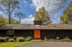 Situated on 7 acres of rolling hills and meadows, this renovated mid-century home offers privacy in a bucolic setting. The sizable entry foyer is brightened by a skylight and built-in bench. The main living room incorporates vaulted ceilings, exposed beams, a large wood-burning fireplace, and sliding doors to access the generous deck with unobstructed views. The formal dining room leads to a kitchen with stainless steel appliances and an exterior door to the pool area. Three bedrooms on the main floor include a primary suite with walk-in closet and full bathroom, two guest rooms, and a second full bathroom. The lower level offers an additional living room with fireplace, third full bathroom, two more bonus rooms, and a laundry room with storage and access to the 2-car attached garage. Outside, you will find an in-ground heated pool, a wood-burning fire pit overlooking the back meadow, and a pond shared with the adjacent property. Established short-term rental. A serene escape, yet just minutes to the Taconic State Parkway. 20 minutes to villages of Rhinebeck and Millbrook.