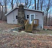 Perched on a mountainside corner lot, this quaint cottage is calling you home. The interior features a functional layout, ideal for simple living. The central point of the home is the living area, offering a great and cozy space to unwind. The kitchen, bedroom and bathroom are situated off the living area. Recently renovated, the bathroom features beautiful wood look floor tiling and a stall shower with pebble tile flooring and built-in shelving. Additional space extends from the living area providing room for a dining table, or whatever you prefer to utilize it for! There is also a second entrance with access to the yard from there. Come discover the charm and comfort of this home!