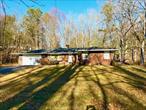 Fabulous Mid Century Modern Brick Ranch located in Sparrowbush NY is only minutes to commuter trains and buses, the Delaware River for recreation, Port Jervis shops, schools and conveniences. Enter this lovely home through a spacious foyer and into a large living room with brick fireplace and natural wood floors, The living room has a serene comfortable feeling with a mid century modern flare. A separate dining room leads into a large galley style kitchen where all your home cooked meals can be made! From the kitchen you can enter an enormous laundry room, perfect to storage, crafts and very comfortable to do your laundry. 3 lovely bedrooms, including a huge primary bedroom with double closets and on suite bathroom. Hardwood floors throughout, attached, 2 car garage and a full open basement for future storage, imagine a rec room and or dream of your exercise room, man cave or she shed.  Outside you have a lovely grassed front yard and in the rear your have a large patio to entertain your family and guests. Well maintained inside and out! All of this only 90 minutes GWB! Come view your dream home today!