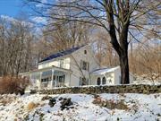 This charming 3-bedroom, 2-bath Center Hall Colonial/Farmhouse, built in 1900, sits on a serene 1.2-acre lot. Featuring beautiful knotty pine flooring with radiant heat, this home blends classic character with modern comforts. The welcoming rocking chair front porch leads to an open and airy eat-in kitchen, perfect for entertaining with its spacious dining area. The kitchen and family room both boast vaulted ceilings, recessed lighting, and a cozy propane stove in the family room, creating a warm, inviting space. French doors from the family room open to a lovely patio area, ideal for outdoor gatherings.The home retains its 1900 charm with the original banister, pocket doors, and some original doors throughout. The dry basement offers ample storage space, and includes a washer & dryer. Additional features include an electronic water purifier, 3 thermostats, and wiring for a generator. Black-top driveway leads to side door of kitchen. Additional driveway that is separate, leads to shed/workshop. With 220-amp service in both the home and the workshop/shed, the property offers plenty of potential. A durable tin roof adds to the homeâ€™s appeal, making this a must-see for those seeking a perfect blend of old-world charm and modern amenities.