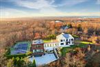 Modern Masterpiece in SouthamptonThis exclusive residence offers a truly exceptional living experience where every detail signifies the ultimate in custom sophistication. This exquisite compound was designed by renowned Architects, Bruce Nagel/Chris Scorgie. With interior and exterior lighting design by Caitlin Faron and Dario&rsquo;s Landscaping designed the grounds to flow seamlessly with this stunning modern home. Situated on a high point just north of Southampton Village, the 2.24 acre property is enhanced by its proximity to acres of reserve at the end of a quiet cul de sac. The home offers distant water views of Peconic Bay from the second floor. Built in 2017, the main house artfully blends modern traditional architectural elements together with the contemporary guest house. The guest wing, main house and lower level total 6746 sq. ft. of living area. Boasting 5206 sq.ft. on two floors with 6 bedrooms, 7 full baths, and 2 half baths. The lower level has an additional 1540 sq.ft. of living space with a media/living room, one bedroom, full bath, and a climate-controlled oversized wine cellar. The main house grand foyer, with its stunning custom lighting and floating staircase, welcomes you to the open concept layout, a chic living room with a magnificent marble gas fireplace, dining room, spacious modern kitchen and den for casual functions. Surrounded by windows overlooking the quiet front and backyard, natural light inundates the rooms and melds the indoors with the meticulous landscaping. The upper floor reveals a primary suite with an elegant bath, two ensuite guest bedrooms with an oversized deck and laundry room. A spacious office capturing the magnificent views completes this floor. The modern jewel guest house connects to the main house by a bridge lined with walls of oversized glass windows. The living /dining area and gourmet kitchen features sub-zero and Wolf appliances. The spacious room opens to a stone patio lounge overlooking the quiet and private backyard pool area, the ideal entertaining space. One half bath and a pool bath on first floor complete the first floor. The second floor features 2 ensuite bedrooms which enjoy treehouse views of the property and preserve. The entire smart house features Luton lights, a wired sound system and is wired for a generator. A 839 sq.ft. two car garage completes the house. The manicured grounds include exclusive amenities such as an all-weather tennis court with an integrated basketball court, a 48&rsquo; x 20&rsquo; heated Gunite pool with an electric cover, an outdoor grill with a built-in barbecue and refrigerator, a gas fire pit, and beautifully landscaped grounds. Nestled in a serene enclave this home offers a luxurious and peaceful living experience for those desiring a Hamptons retreat. Listing ID: 918175