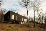 Up a winding country drive in a beautifully rural part of southern Columbia County, a modern house is notched into the hillside. West facing toward the sunset, the home was built to frame a magnificent view of the Catskill Mountains. The interior has wonderfully high 12ft ceilings and wideboard white oak flooring. The large Great Room features a striking wall of glass looking out over the landscape. In the open kitchen you&rsquo;ll find a Sub-Zero refrigerator and Wolf range, and at the far end of the room is a woodburning fireplace and wet bar. There are four ensuite bedrooms including a beautiful primary suite, all with big views, and downstairs the finished lower level has radiant concrete floors, a sauna and a media room. The systems are top of the line with geothermal heating and cooling. The pool is heated with a big view, and the pool house has shiplap white walls, concrete floors and two built in queen daybeds. There is a kitchenette and a full bath with a shower. The house is completely private with no neighbors in sight. The two car garage is currently set up as a gym & garage space. Completely turn key, well executed modern luxury just 2h north of NYC.