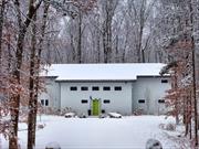 Nestled on 9 acres of private, sought-after land, yet just a mile from the vibrant town of New Paltz, this ultra-modern home offers an unparalleled living experience. The driveway ushers you into a world of tranquility, where contemporary design meets natural beauty in perfect harmony. Combining innovative design, modern amenities, and energy-efficient living, this architectural gem offers a contemporary lifestyle infused with the tranquility of nature. The single-pitch, standing-seam roof and sleek metal siding seamlessly blend with the lush surroundings, offering a striking first impression. Step inside to discover the home&rsquo;s unique character, highlighted by its insulated concrete construction and two polished concrete walls that create a bold, custom aesthetic. At the heart of the home lies a gourmet kitchen designed for culinary enthusiasts, featuring top-of-the-line appliances, granite countertops, and a spacious peninsula bar perfect for cooking and entertaining. The kitchen&rsquo;s open design extends to the second floor, showcasing a dramatic 24-foot wall with eight-foot windows that flood the space with natural light and offer breathtaking views of the surrounding woods. The first-floor primary suite is a luxurious retreat, complete with an ensuite bath featuring a deep soaking tub and a separate tiled shower for a spa-like experience. Each additional bedroom also boasts its own private ensuite bath, ensuring convenience and privacy for all. Outside, a wrap-around patio invites you to dine al fresco, relax, or simply take in the serene beauty of the property. A hot tub provides the ultimate spot for unwinding while soaking in the starry night sky or the lush, green landscape. This home isn&rsquo;t just about beautyâ€”it&rsquo;s designed with energy efficiency in mind, featuring radiant heat within the polished concrete floors for year-round warmth and comfort. Just a mile from New Paltz, this home is an exceptional opportunity for those seeking a sophisticated, serene escape.