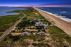 Welcome to 27 Dune Road, East Quogue, a unique oceanfront haven. This property boasts not one, but two beautifully transformed beach cottages, nestled on an expansive 0.87 acre lot with 75 ft. of ocean frontage. Enjoy uninterrupted 360-degree bayfront views, a sight that promises tranquility. Crafted to perfection in 2019 by Coastal Management, each cottage is a testament to exceptional craftsmanship, featuring custom-designed kitchens, dining and living areas, and a loft. The bayfront cottage offers three bedrooms, two bathrooms, a sunset-viewing deck, and an Oceanside patio. The oceanfront cottage, designed for those seeking privacy, provides a primary bedroom, 1.5 bathrooms, and ample outdoor spaces for beachside entertainment. The loft above adds an extra layer of charm and functionality to these delightful spaces. The upgrades are notable, including new mechanicals, full-sized washer & dryer, water filtration system, custom built-ins for extra storage, and a shed for bicycles. An outdoor shower, a sandy sitting area, and a private walkway to the ocean enhance the outdoor living experience. This unique property sits adjacent to town-owned land, offering additional privacy. With direct ocean access and unobstructed sunset views, 27 Dune Road is a rare find you won&rsquo;t want to miss.