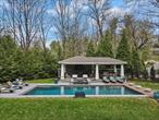 Set on 3.19 acres of tranquil woodland in a coveted Rye Brook enclave, this exceptional contemporary residence offers privacy and seamless indoor-outdoor living. Thoughtfully renovated to blend modern luxury with its Frank Lloyd Wright-inspired design, the 6, 663 sq ft home with 6 bedrooms and 4 baths showcases dramatic open spaces, clean architectural lines, and natural materials throughout. An expansive living room flows to a stone porch overlooking lush lawns and a charming wooden footbridge. The chefâ€™s kitchen with oversized center island and informal dining area enjoys wrap-around views, opening to an inviting gazebo with full outdoor kitchen, hot tub, and splendid in-ground pool. The distinctive hexagonal library adds architectural character and charm, while the formal dining room, spacious den, and private office with tennis court views exude classic sophistication. The second level features a remarkable primary suite with gas fireplace, palatial lux bath with feature tub and oversized shower, Toto toilet, generous double walk-in closets and elevated balcony. Five spacious additional bedrooms on the upper-level offer flex spaces for family, guests, home office, or gym. Enjoy effortless living in this open, light-filled home. AN ADDITIONAL PRIVILEGE: RESIDENTS HAVE THE OPTION TO CHOOSE BETWEEN THE SOUGHT-AFTER HARRISON AND RYE BROOK SCHOOL DISTRICTS.