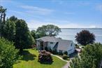 Own a west-sided prime piece of waterfront property in the Village of Kings Point. This perfectly positioned 2-story Shingle and Brick Colonial sits on 1.34 acres hugging the Long Island Sound. This 6 bedroom, 4.5 bathroom home features beautiful hardwood floors, a formal dining room, a eat-in-kitchen, a spacious living room, a family room with a fireplace, a 2-car attached garage, two saunas, and a finished walk-out basement leading out to water views. The manicured grounds display a waterfront pool, a gazebo, an outdoor shower, an expansive multi-level deck, brick patios, and stairs that lead down to your very own sandy beach. Unique aspects include an impressive Japanese Maple tree and rock garden, natural rocks with a landing along the shoreline, and an 18th Century French Castle hand-carved door. Enjoy unrivaled panoramic views from Manhattan to Connecticut, including magnificent sunsets, and amazing firework displays on July 4th - for your own pleasure or for entertaining others.