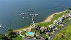 DIRECT WATERFRONT ON LONG ISLAND SOUND only 23 miles from NYC!! Located in the only Gated Waterfront Community with its own Private Marina & Boat Slip. Legend Yacht & Beach Club is a spectacular community of free-standing homes with a 24-hour manned gatehouse, two-story waterfront clubhouse, pool & pool terrace, indoor clay tennis court, sandy beach, ponds, garden areas and mature landscape. Set on the historic Pembroke Estate which was once owned by Arthur Loew of Loew&rsquo;s MGM Movie Theaters. This pristine custom designed home offers a first-floor primary suite & covered porch with outstanding views of LI Sound & the private marina. The property features spacious rooms throughout with bright spaces, soaring ceilings, floor to ceiling windows highlighted by rich wood floors and all with magnificent views of the water & amazing sunsets. The Kitchen is large with a granite topped center island and lovely breakfast room adjacent to the Den with fireplace & attractive built-In Cabinetry. There is also a spacious living room with fireplace and soaring ceilings overlooking the water, formal dining room, cozy den, three additional bedrooms and 3.5 baths. Extensive Brazilian walnut wood decking extends the entire length of the home with two covered sections off the Kitchen & Primary Suite. The property is a blend of modern conveniences with traditional charm. Ideal for Relaxation and Entertaining this magnificent retreat is the home for full time living or a perfect Hamptons Alternative. Also included are resident privileges at Glen Cove Golf Course.