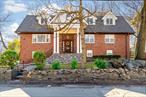 Discover a true gem hidden in plain sight! Situated on a bucolic street shared by Mt. St. Vincent University, this stunning 5, 100 sq ft Colonial home offers pleasant suburban living in the city. Thoughtfully designed flow of space takes you through the traditional foyer into a generously sized living room with loft ceiling. Formal living room is complete with dramatic windows and a wood burning fireplace so you can enjoy brisk sunny mornings and relaxed evenings in the warm glow. FLR is adjacent to a family room for more casual gatherings. In the East wing of the house you will find the state-of-art renovated kitchen which leaves nothing to be desired even for the pickiest chefs. Some of the highlights here are: five burner stove with a double zone oven, soft close hardwood cabinetry, dual convection oven/microwave, two kitchen sinks, separate wine and soft drink fridges, and an industrial grade vent hood. Abundant counter space turns any meal prep into a culinary adventure and having a dedicated bay window breakfast nook adds a sweet touch to it. The kitchen leads into a formal dining room with plenty of space to entertain on bigger occasions. Half a bath located in this area is a perfect addition. In the West wing you will find two bedrooms, one of which sports a full bath, and one more full bath in the hallway. Second floor is flooded with natural sunlight pouring through large skylights. The bigger of two bedrooms in the East Wing features vaulted ceiling, while the cozier one has a walk-in closet in addition to a regular closet. This area has one full bath. Taking the catwalk to the other side of the house, you will be stunned by the primary suit which takes the entire West wing. Primary bedroom features cathedral ceiling, wall-to-wall shoji screen closet, additional walk-in closet and a primary bath of your dreams. A shower stall, an oval tub, double vanity and a skylight to enjoy the starry nights while taking me-time - what else can you wish for? The lower level of the house hosts a spacious game room with an access to the yard, designated laundry area with washer & dryer machines, and a bonus bedroom with a big closet. Full bath on this level boasts a steam room with heated floor feature. The open area on this level features a home gym. From this level you can enter the garage with a double height ceiling and two utility rooms. But the marvels do not stop here. The house is complete with an oversized deck which invites all types of fun: there are two eating areas conveniently located just outside of the kitchen. And those who love to pamper themselves will surely appreciate the sunken hot tub on the deck. The garden is full of mature peonies, roses, and picturesque trees providing some shade in the summer. The house runs multi-zone heating and cooling zones with a smart thermostat regulating a complex system of hot water and forced air heating zones for your maximum comfort. Have a peace of mind with a brand new roof with 50 year warranty. The area of North Riverdale Estates is what a lot of notables, such as former presidents and Hollywood stars, call home. Located next to Wave Hill park, great restaurants and some top public and private schools, among which are Horace Mann, Riverdale Country Day and Manhattan College, this rare find will not linger on the market. Come on in and make this impressive and private residence YOURS.