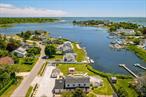 Opportunity abounds with this waterfront, 4+ bedroom, 4-bathroom, approximately 2, 400SF home on a large lot in Southampton. Panoramic views of Shinnecock Bay, low taxes and potential to add a pool & dock are just a few of its intriguing features. The stone paved driveway is large enough for multiple cars and boats. A pergola and deck off the back of the house with built-in bench seating and lounging areas provide abundant outdoor living space and take full advantage of the amazing waterfront views. The home&rsquo;s interior offers an excellent layout for hosting guests and entertaining. Enter into a formal living room with a marble fireplace and French doors leading out to the sun-drenched yard. An eat-in kitchen with custom cabinetry leads out to the deck through French doors that let in natural light and water views. A more casual family room off the kitchen offers a comfortable place to relax. A first-floor primary suite includes a marble bathroom with a soaker tub, separate glass-enclosed shower and a steam room. A convenient powder room completes the first floor. Upstairs are three guest bedrooms, a full bathroom, an office and a sitting area with direct access to a balcony and stairs down to the main deck. This layout could also work well for a mother/daughter set up or passive rental income. Completing this property is a detached cabana/artist&rsquo;s studio. Enjoy the beauty of this waterfront location while also being close to the village.