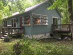 Welcome to a Rustic Cottage in the woods, ranch style living with cathedral beamed ceiling and an open floor plan, living room, dining room and kitchen. 3 Bedroom plus 2 full baths, reading nook area. Living room has sliders that lead to a wraparound deck overlooking the community inground olympic size swimming pool and you can clearly hear the sounds from a babbling brook. So, if you are looking for a summer home, tucked away weekend getaway or year-round living come see all the Hudson Valley has to offer.  Move in and make it your own. Less that 1 hour to NYC. Home comes with a new septic and approximately 8-year-old roof. Community of 12 homes on 17 acres, held in a Stock Owners Corporation. Residents must be approved by a self-managed board prior to proceeding to contracts. For these reasons community is not mortgageable and must be cash offers only. But comes with seriously reduced taxes by being held in this form. Public record has it zoned Multiple Family Buildings. No investors, home cannot be rented. Home was previously converted to year-round living but used recently used only as a summer home. Waiting for your personal touch. Heat has not been used and ductwork is unusable. Price reflects the need of new heating system. A rare discovery.