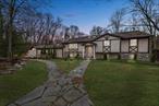 Welcome Home! To this oversized, charming raised ranch with a bonus in-law suite extension to the main house. This home is nestled on a lush, wooded lot. The property offers a serene retreat with two entrances, allowing you to drive right up to comfort and convenience. The interior showcases beautiful high ceilings and large windows throughout the living/family room, with an expansive sunroom that offers a lot of natural sunlight. The multi-tier composite deck offers all the outdoor space for summer months get togethers. Complemented by an in-law addition with 1 bedroom and a den/office, a full bath with an open floor plan and its own laundry room. The main house has a large finished walk-out basement to screened-in porch. Conveniently located near the highway, this home offers easy access to nearby amenities while maintaining a peaceful, natural setting. Schedule your private tour today.