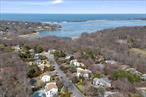 Indulge in breathtaking vistas of Mount Sinai Harbor, the Long Island Sound, and Connecticut from multiple rooms of this extraordinary home. The rooftop deck offers a spectacular panoramic experience, perfect for relaxation or entertaining.This meticulously maintained property boasts a stunning eat-in kitchen with newer stainless steel appliances, a serene primary suite featuring an en suite bathroom with a luxurious jacuzzi tub, and a host of recent upgrades including a Roth double-lined fuel tank, a newer Bosch CAC system, freshly painted interiors, a new roof and siding with updated skylights. The landscaped grounds are a masterpiece, showcasing extensive new retaining walls, graceful walkways, a tranquil koi pond with a cascading waterfall, and vibrant seasonal gardens that delight throughout the year. The lower level opens to a private and peaceful yard, offering a perfect retreat from the bustle of life.Nestled within the prestigious Port Jefferson Village, residents enjoy access to exclusive amenities including golf, tennis, private beaches, and activities like fishing and kayakingâ€”or simply unwinding by the shore. Conveniently located near three major North Shore hospitals, this home seamlessly blends luxury and practicality.