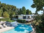 Set on approximately 2.5 acres of serene land, this 5-bedroom, 5.5-bathroom, approximately 6, 500 square feet residence is a rare find, cherished by only two owners in 56 years. Blending luxury with the timeless charm of a California-style mid-century design, the steel-beam construction, restored by acclaimed architect Deborah Berke and builder David Prutting, features radiant flooring, a spa-like primary suite, and 16 skylights that flood the home with natural light. Outside, a stone patio, heated pool, and pergola with a sunshade overlook lush greenery. The home includes a 3-car heated garage, 5-zone central air, a gym, sauna, and a full lower level with two bedrooms. Winner of the 2015 Hudson Valley Design Award, this meticulously crafted residence offers serenity, comfort, and modern amenities in a peaceful community.