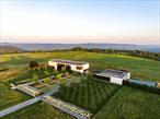 A Private Architectural Masterpiece on 165 AcresNestled along the border of Amenia and Millbrook, NY, this extraordinary 165-acre estate offers unparalleled privacy and breathtaking panoramic views of the Hudson Valley. Designed by the acclaimed Resolution: 4 Architecture and completed in 2019, the 7, 500-square-foot modern residence harmonizes seamlessly with its natural surroundings.At the heart of the estate is a regulation-size polo field, framed by sweeping vistas that stretch as far as the eye can see. The main house is thoughtfully divided into two wings, separated by a striking glass pivot door in the entry foyer. The service wing features a chefâ€™s kitchen, pantry, mudroom, and powder room, while the entertaining wing boasts a dramatic great room with a black steel-surround fireplace and 70 feet of floor-to-ceiling glass overlooking the landscape. Additional spaces include a media room with its own fireplace, a hidden office tucked behind a sliding door, and a gym.Ascending via the main staircase or elevator, the second floor reveals an exceptional outdoor entertainment area complete with a full bar, dining space, and a lounge with a wood-burning fireplace, all overlooking the valley. The private primary suite offers a serene retreat, featuring a wood-burning fireplace, a meditation room with a gas fireplace, and two dressing rooms. The suiteâ€™s spa-like bathrooms include a freestanding soaking tub set against a wall of glass for uninterrupted views, an outdoor shower, and a stone-clad shower with luxurious finishes. Three en-suite guest rooms are located at the opposite end of the hall, ensuring privacy for visitors.The estateâ€™s pool house serves as an oasis unto itself, featuring a kitchen, lounge, and half-bath. An adjacent outdoor dining area blends into the landscape, providing the perfect setting for al fresco gatherings. The infinity pool seamlessly merges with the valley views, complemented by a spa, outdoor shower, and ample lounging space. Connected to the pool house is a three-car garage and a picturesque courtyard with a dramatic, tree-lined Belgian block and mossy parking area.Designed by award-winning landscape architects Wagner Hodgson, the estateâ€™s grounds pay homage to the homeâ€™s modern architecture, with stone walls, weathered steel elements, and native plantings that enhance the natural beauty of the property. The barns, equipped with 48 stalls and multiple paddocks, currently serve as a premier polo facility but could easily transition into an elite show-jumping stable. Lush gardens, restored meadows, a croquet court, and two staff housesâ€”one with three bedrooms and another with twoâ€”complete this one-of-a-kind estate.A rare offering in the Hudson Valley, this property is an exquisite fusion of modern design, equestrian excellence, and unparalleled natural beauty.