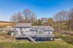Exceptional! Come take advantage of the rare opportunity of owning this stunning renovated Colonial style home from 1952 which underwent a stunning transformation with a contemporary additions in the late 1980s and most recently in 2024. Nestled on nearly 2.5 private acres of scenic land and water views in the desirable town of Goshen, NY. Just 39 miles from NYC. Embrace the outdoors with the twin ponds. Offering the perfect blend of comfort, functionality, amenities and serene surroundings. This recently renovated home boasts a stunning kitchen complete with sleek GE Cafe luxury appliances, and an elegant coffee bar which connects to the formal dining space. The main floor boasts 3 bedrooms , 3 full baths in total which include a master bedroom suite.  This home also features an expansive living room, the perfect gathering spot for relaxing or entertaining which also connects to the huge backyard deck with a tranquil water view of the two small ponds, which also belong to the property. Just a few steps away you will also find a beautifully sized family room, with a convenient half bath for guests, huge basement as an accessory unit with 3 extra rooms plus a full bathroom, kitchen and laundry room which also has full access to the backyard. Parking features: 2 Car attached garagge. Heating Fuel: Oil Below Ground. Come see the this incredible property for yourself.