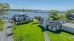 Experience the ultimate in coastal living with this extraordinary waterfront compound, privately nestled in the sought-after Holiday Beach community. This rare offering features a spacious main residence and a fully renovated guest cottage, perfectly designed for luxurious living and effortless entertaining.The main house welcomes you with a flowing layout that includes a dramatic great room, formal living room, elegant dining area, and a bright eat-in kitchen. The expansive primary bedroom boasts its own private terrace with stunning water views, while two additional bedrooms, a dedicated home office with its own bathroom, 2.5 more baths, and a full laundry room complete the interior. Step outside onto multiple levels of decks that offer panoramic views and unforgettable sunrises over the water. The guest cottage is a retreat in itself, beautifully renovated with vaulted ceilings and sophisticated finishes. It features a large ensuite primary bedroom with a generously sized walk-in closet, a versatile second bedroom/loft, and an open-concept family room with a cozy fireplace and dining area. The high-end eat-in kitchen is a chefâ€™s dream, outfitted with sleek stone countertops, custom Ciuffo cabinetry, and premium stainless steel appliances. The cottage also includes its own laundry area and private garage. Outdoor living is just as impressive, with a stylish cabana with shower, a cold plunge pool or tub, and expansive decking that invites relaxation and entertaining. A deepwater dock extends 150 feet and includes water and electric, offering easy access to the inlet and bay for boating enthusiasts. Additional features include ductless air conditioning, central vacuum system, and deeded beach rights to Holiday Beach. Located just minutes from the Hamptons, this exceptional property provides easy access to world-class shopping, dining, and pristine beaches, all while offering the privacy and tranquility of a waterfront sanctuary. Call today for a private showing.