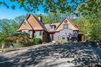 Tucked on a quiet private road under ten minutes from Rhinebeck Village, this 5-bedroom custom craftsman estate offers beautiful, high quality art-deco style for those seeking a break from the sea of sterile new builds and stark modernism. Built with the utmost quality, oak floors, premium custom windows and doors, and brass hardware throughout. A bevy of high technology make the home energy efficient and off-grid ready, while luxuries like an indoor lap pool, hot tub, steam shower, and jetted tub offer the very best of comfortable modern living.The main home is a spacious 4, 566 square feet of post-and-beam construction, with soaring ceilings creating an airy, lodge-like feel. The heart of the home is anchored by a dramatic bluestone fireplace surrounded by sun-drenched living and dining areas with double-height windows and exposed beams. The chefâ€™s kitchen features a 6-burner Wolf stove, warming drawer, wine fridge, pot filler and rich custom cabinetry grounded by hand-stamped tile floors.The floor plan flows effortlessly: a main-floor guest suite with en-suite bath, a spacious media room, office space or playroom, a Brazilian walnut rear deck and sunroom with a swim spa and hot tubâ€”climate controlled for year-round enjoyment. Upstairs, the primary suite is a tranquil retreat with a steam shower and jetted tub, and there is another ensuite bedroom and mezzanine level replete with custom built-ins.Downstairs, a walkout fourth bedroom, living area, and full bathroomâ€“perfect for in-laws, a home office, with space to add a service kitchen for a fully contained unit. A laundry room with a 2-story laundry chute, a walk-in pantry, and utility room complete the lower level. The home is impeccably maintained and loaded with upgrades: solar panels, energy-efficient heat pumps with a high-grade backup oil furnace, backup generator and central-station alarm system.Separate from the home, a matching 1, 344 square foot two car garage with keypad entry, and above it, a 672 square foot legal ADU (accessory dwelling unit), complete with a kitchenette, full bathroom, central heating and air conditioning, and walkout deck, currently a professional music studio. Outside, five lush acres offer perennial gardens, a koi pond, and hand-laid stonework in a deeply peaceful setting. This is a home with soulâ€”and a very rare find in todayâ€™s market.