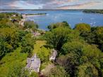 Centre Island. Step into timeless elegance at this distinguished 3-acre English Country-inspired property, ideally situated amongst storied Gold Coast estates. This stately residence blends classic stucco architectural detail with modern luxury, offering privacy and year-round water views. A grand entry foyer welcomes you with a sweeping bridal staircase and soaring ceilings, bathed in natural light from expansive windows. French doors lead into a magnificent, ballroom-style living roomâ€”ideal for hosting formal gatherings. The main level also features an exquisitely detailed formal dining room with custom details, a large sized den with a fireplace that invites relaxation, and a granite chefâ€™s kitchen with premium appliances and panoramic views of the harbor. Perfect for both entertaining and day-to-day living, every space flows seamlessly while offering character and architectural distinction. Upstairs, the primary suite is its own private retreat, showcasing dramatic double-height ceilings, fireplace, its own staircase, elegant architectural columns, and three spacious walk-in closets. The en-suite bath is spa-inspired, with luxurious finishes, a soaking tub, and separate vanities. Step out onto your private balcony to take in sweeping, uninterrupted water views. Four additional well-appointed bedrooms and three full bathrooms complete the second level, offering ample space for family and guests. The grounds are a true highlight, with circular gravel driveway approach, lush, manicured lawns, mature specimen plantings, and multiple outdoor entertaining areas. A detached three-car garage with attic space completes the property. A true haven for those seeking luxurious North Shore living with historic charm and coastal beauty. Located one block from Seawanhaka Yacht Club and close to distance to Centre Island Beach. Oyster Bay SD.