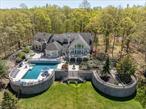 CHATEAU AMOUR - Where every sunset tells a love story... Need privacy? Look no further! Surrounded by Clausland Mountainâ€™s vast 532-acre nature preserve, this impeccably rebuilt 2007 custom estate at 172 Clausland Mountain Road blends wild beauty and refined luxury with 8, 000 SF of finished living space. While you feel a world&rsquo;s apart in your own 5.5 acre sanctuary, it&rsquo;s hard to imagine you are only 30 minutes from NYC and less than 10 minutes to the majestic Hudson River and the river town villages of Nyack & Piermont, all within the award-winning South Orangetown School District. A gated tree-lined driveway welcomes you to a 17-room masterpiece featuring four ensuite bedrooms, seven bathrooms and six fireplaces for a warm, yet regal ambiance. The centerpiece is an expansive kitchen with a towering fireplace, high-end appliances and a 10-foot island, seamlessly extending to granite patios, royal gardens and a fully equipped outdoor chef&rsquo;s kitchen with fireplace, enclosed by Mediterranean-style balusters and secure gates. The grounds include a gated Bonsai garden and koi pond with cascading waterfalls that glimmer under the stars. For leisure and entertaining, enjoy the the panoramic nature views from bountiful patios, including a heated saltwater pool, outdoor fireplace and two hot tubs. If your own slice of heaven isn&rsquo;t enough, with plenty of room for vegetable gardens, vineyard vines, orchards, livestock, tennis court, and even a helicopter pad, bask in the wild through private trails into Clausland Mountain State Park, where endless exploration awaits. The entire setting is like living in a 360 degree perpetual mural that changes by the season; where your view shifts from fall foliage out of a Van Gogh painting, to a Monet winter wonderland. Abutting the property is a magical natural pond, the perfect backdrop for a picnic, swing or an ice skating haven in the winter. Inside, the list goes on and the house doesn&rsquo;t skip a beat, from first floor bedroom, wine cellar, butler&rsquo;s pantry, private office with extensive millwork, meditation room, smart home systems controlled by phone and a finished basement with theater and bar that leads directly to the lush grounds. The separate primary suite wing features vaulted ceilings, a fireplace, wet bar, walk-in closet and a balcony with private hot tub. If the house is too much to explore on foot, take advantage of the elevator which goes to every floor, warm your feet on the radiant heated floors and have the piece of mind your sports cars will enjoy the heated three-car garage. Minutes from the Hudson River and the charming villages of Piermont and Nyack, this property combines secluded living with everyday convenience. Whether you are looking to host or hideaway, 172 Clausland Mountain Road is where art, nature and architecture converge in romance...