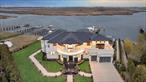 Welcome to 190 Curtis Road, a newly constructed 9, 200 sq ft luxury modern residence located on a cul-de-sac in Hewlett Neck, offering panoramic views of Brosewere Bay, Georges Creek, and the South Shore coastline. Situated on a private 0.61-acre lot, this 7 bedroom masterpiece blends high end finishes with sophisticated design and premium waterfront amenities for daily living. Designed with soaring ceilings, oversized format stone tile floors, and a dramatic mezzanine, the home offers a grand, open concept layout. The chefâ€™s kitchen showcases a 17-foot island, dual sinks, and top of the line Dacor appliances, along with a built in Miele coffee station and custom bar. State of the art theater room, integrated iPads, and a 12-zone Sonos sound system deliver seamless a full smart home lifestyle.Second Level Five oversized bedrooms each feature private balconies. The primary suite includes two walk-in closets and a spa-inspired bath with a bay window.The backyard was designed for elevated outdoor living, featuring a 1, 400 sq ft heated saltwater pool finished in imported mosaic tile from Portugal, a fire pit, and a full cabana with an outdoor kitchen, full bathroom, and outdoor shower â€” ideal for entertaining. The outdoor kitchen includes a sink, built-in gas BBQ, electric smoker, refrigerator, and wine cooler. The private floating dock offers slips for 2 boats and multiple jet skis. A brand-new bulkhead completes the waterfront setting.Additional features include the imported Spanish clay roof, hurricane rated Series A Andersen architectural windows, 3-car garage, floating butcher block staircase, advanced security system with 22 surveillance cameras, and full house Generac backup generator.