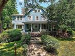 Introducing The Spring Hill House, a rare gem in the heart of Monroe, a short stroll to Kiryas Joel Gate shopping & conveniences. Set on 2.6 serene, park-like acres, this Queen Ann estate, offers both a grand main house & a potential accessory home. The elegant interior boasts a custom kitchen w/ luxurious marble & onyx backsplashes & countertops hardwood floors, formal dining room, living room, den, a raised hearth stone fireplace, & a tranquil screened-in porch. The second floor unveils 4 beautifully appointed bedrooms, a newly renovated 2.5-bath layout, & a stunning all-season sunroom. The 3rd floor office suite features granite finishes & bespoke wood cabinetry (easily converted to family room, bedroom, theater, library)Experience year-round comfort w/ geothermal energy, reducing heating & cooling costs up to 70%. Atop Spring Hill, the 1, 400 sq. ft. Carriage House awaits transformation into a guest residence. Enjoy gatherings by the private pool & stone patio, seamlessly blending historic charm w/ modern luxury. Zoned SR20 for subdivision potential.