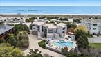 Experience 150 feet of pristine oceanfront in this fully renovated contemporary masterpiece, boasting panoramic 360 degree views of the ocean and bay. Designed for seamless indoor-outdoor living, the home features expansive multi-level decks, a private boardwalk to the beach, and floor-to-ceiling glass sliding doors that frame breathtaking water views from every room. This 6 bedroom, 7.5 bathroom stunner is thoughtfully designed with two private wings for comfort and separation. Enter through a dramatic foyer with cathedral ceilings into an ocean facing living room, where double sliders open to a sprawling deck and direct beach access. The open concept layout flows into a custom kitchen featuring stainless steal appliances, leathered Naica quartz counters and island with waterfall edges, and bespoke cabinetry. A large slider leads to the bayside deck and down to the pool terrace. The first floor includes three en-suite bedrooms. In the left wing, you&rsquo;ll find a powder room, laundry, and a junior primary suite with ocean views, a fireplace, walk-in closet, and private deck access. Upstairs, the primary suite offers a serene retreat with a fireplace, sitting area, walk-in closet, and a spa-like bath with shower and water closet. The right wing boasts two more en-suite bedrooms and a second staircase leading to the upper level, where two additional en-suite bedrooms provide flexible accommodations for guests and family. Outdoors, enjoy the heated bayside gunite pool and hot tub, adjacent to a fully equipped kitchen with built-in BBQ, fridge and freezer drawers, ice maker, and sink. An outdoor cabana with bathroom and storage completes this ultimate waterfront escape.