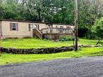 Drive down the long private driveway to a secluded 13.8 acre wonderland. Nestled in the perfect location close to everything is 20 Wildwood lane Waiting for someone to bring is property back to life. A large Double wide manufactured home in need of some TLC featuring 3 bedrooms, 2 full bathroom, spacious kitchen, large open living/dinning room combo and a family room which features a wood burning fireplace. Just steps away from one of two large ponds. Large fenced in area could be the perfect garden. Large outbuilding with endless potential. Listen to the natural spring run from the front porch. With some tlc this property can be a dream come true. Great commuter location. Close to all local amenities.