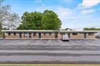 This commercial rental offers a functional layout including two private offices or client rooms, a designated waiting area, and a front reception desk. The unit is further equipped with a kitchenette and one bathroom. Tenants will appreciate the abundance of off-street parking and the ease of access. This adaptable space can accommodate various business types, including professional offices (real estate, insurance, bank), personal services (beauty/barber), and potentially some retail or food-related ventures.