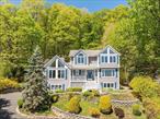 Welcome to the best of Village living in this spacious, Victorian-style colonial home with breathtaking, four season Hudson River and Cuomo Bridge views set on 2.3 acres, minutes into downtown Nyack. Expansive great room with 22ft soaring vaulted ceiling, walls of windows which bring the outside indoors, custom built-in cabinetry and a dramatic dual-sided stone fireplace complete the elegant and inviting space. The large, open and updated eat in kitchen featuring stainless steel appliances, center island with quartz countertops and marble backsplash is the perfect centerpiece of the home. It leads to multi level decking, patio spaces, lush gardens and your own 2 plus acres of private woodland sanctuary, bordering on Clausland State Park. For nature lovers, hike in, hike out without getting into your car! Completing the first floor, enjoy large family gatherings in the banquet-sized dining room complete with Hudson River views as your backdrop. The top floor master bedroom suite sits high above the Hudson, filled with light, lofty ceilings and wondrous views by day or night. Newly renovated ensuite bath complete the luxury with walk-in shower and spa like soaking jet tub. Three additional bedrooms and bathroom complete the top floor, each with its own unique charm, privacy and views. Bonus walk-in level for additional flexible guest, in-law, au pair or professional office space includes another full bathroom, playroom area, 2 car garage, sizable storage, cedar closets and more in this well cared for home. This home really does have it all and is conveniently located only 18 miles to the GWB.