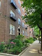 Just look out any of the ten windows in this four-room apartment and you gaze upon the beautiful and lush Hampton Court garden. Located on the (raised) first floor, the apartment has three exposures â€“ south, east and north â€“providing great light, while the garden feels like your own backyard! The foyer welcomes you to the apartment, with three closets to the right, along with the renovated bathroom. Straight ahead is the hall which leads you to all of the other rooms. On the left is the renovated kitchen. There are white cabinets and black quartz countertops along with a door directly to the dining room.  And on the right is the bedroom with two south-facing windows. Added sound proofing was added above the bedroom ceiling. At the end of the hall is a French door that leads you into the spacious living room with three windows facing east and south. A pair of French doors separate the living room from the formal dining room, with three windows facing east and north. And while this unit was recently renovated â€“ including complete new electric, it also retains great prewar details, including 9â€™ ceilings, perfect walls and ceilings, oak-strip floors, and moldings. This is a walkup building. Hampton Court was designed in 1921 by George H. Wells, and its eleven buildings surround one of the loveliest internal gardens in the Jackson Heights Historic District. This building is well maintained and has laundry facilities and a free storage bin in the basement. 25% down. Subletting is not allowed, nor are dogs. No flip tax. Centrally located in the Jackson Heights Historic District, this building is close to restaurants, shopping, our weekly Greenmarket, and but a handful of blocks to the 74th Street/Roosevelt Avenue train and bus station.