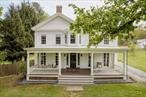 This stately Greek Revival sits proudly on a generous village lot in the historic Hamlet of Hillsdale. Dating back to c.1848, the home boasts beautiful architectural proportions and details. Pilasters accent the exterior corners of the house and a front- and side-gabled roof add additional grandeur. Arrive via a front porch â€” running the full width of the facade â€” framed with Doric columns. The front door, surrounded by two glass sidelights and topped by a transom window, leads into a center-hall / foyer. To the left, a front parlor flows into a generously sized dining room. Elegant moldings encase the windows and doorways. Beyond the dining room, a commodious kitchen with large Viking gas range and double-bowl farmhouse sink entices any gourmand. Two walls of windows allow light to flood the space, and a wood-burning stove adds extra warmth and air of coziness. A large pantry offers ample space for storage and organization. Off the kitchen a four-season sunroom drenched in light contains a gas-burning fireplace and access to the yard. A wet bar, found off the dining room, features a charming booth overlooking a stone patio. A full-length parlor occupies the western side of the house. It features an electric fireplace as well as a fully enclosed nook with another wood-burning stove. A powder room is found tucked behind the parlorâ€™s interior wall. Upstairs five bedrooms and two full baths surround the second-floor landing. The primary bedroom opens to an office space with a third full bath. Outside a large barn contains a hot tub, workshop and abundant storage. The yard is fully fenced and spacious, perfect for letting pets off-leash as well as outdoor entertaining. The home strikes a balance between historic and contemporary, with plenty of room to spread out. Walk to shops, restaurants and grocers located in the Hamlet of Hillsdale. Located 20 minutes to Hudson, 15 minutes to Great Barrington and just minutes to skiing and summer recreation at Catamount Resort, this home is ideally situated for exploring the upstate lifestyle.