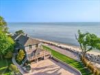 Experience the pinnacle of waterfront living in this exceptional 4, 000 sq ft Asharoken estate, boasting the most coveted views and the second-largest water frontage after the famed Morgan Estate. This custom-built contemporary offers approximately 220 feet of private sandy beach along the Long Island Sound, providing dramatic, unobstructed 180-degree water views from nearly every room. Revel in the open-concept design featuring a stunning kitchen with custom details, luxurious custom closets, and a palatial ensuite primary bedroom with dual private decks and a spa-inspired bathroom. With premium finishes like Pella windows, soaring ceilings, and multiple Trex decks, this residence is designed for sophisticated coastal living.Beyond its striking aesthetics, this property offers unparalleled convenience and peace of mind. Enjoy the separate guest quarters, two gas fireplaces, and a walk-out basement leading to the garage. Recent upgrades include a brand-new septic system, a new driveway, a new privacy gate and landscaping enhancements. Benefit from the rare advantage of not requiring flood insurance and the security of a full-house generator. This Diamond+++ rated home is a true sanctuary, offering a permanent vacation lifestyle in one of Long Island&rsquo;s most desirable locations.