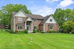 Welcome to this elegant contemporary colonial home, perfectly blending a relaxed atmosphere with luxurious details across 3.1 professionally landscaped acres. Step inside and make a grand entrance through the dramatic foyer, featuring stunning in-lay hardwood floors and stately columns. The expansive living room offers a sophisticated formal space for traditional furnishings and elegant entertaining. Enjoy mealtime in a setting that exudes gracious formality. The two-story family room, complete with a warm fireplace and a convenient wet bar, is sure to become the heart of your entertaining. The first floor also features a desirable home office enhanced by a unique two-sided fireplace. The large kitchen offers both efficient style and inviting warmth, boasting beautiful quartz countertops, top-of-the-line stainless steel appliances, a spacious eating area, and a center island perfect for casual meals or serving as a buffet. Retreat to the luxurious primary suite, a true spa-like haven with a separate shower, double sinks, a whirl pool tub, and a generous walk-in closet. The home also includes three additional well-appointed bedrooms and a versatile bonus room, each sharing thoughtfully designed Jack & Jill bathrooms. Outside, discover your own private resort with a sparkling inground pool nestled within the beautiful, park-like property featuring gorgeous landscaping. This exceptional home enjoys an excellent location, just minutes away from charming village shops and restaurants.