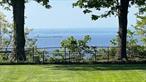 Leahead â€“ A Gold Coast Waterview Masterpiece with Exclusive Beach Rights. Welcome to Leahead, a rare and remarkable 1896 waterview estate in Glen Coveâ€™s prestigious Red Spring Colony, offering exclusive beach rights to Red Spring Colony Beach. This lovingly restored mansion seamlessly blends historic grandeur with modern luxury on 1.34 acres of landscaped gardens, tranquil woodlands, a sparkling pool with waterfall, a spa, overlooking the Long Island Sound. With a story as rich as its architecture, Leahead was originally built by Henry W. J. Bucknall, an English-born businessman and successful cork importer. In 1897, Bucknall purchased a five-acre parcel in what was then a newly forming enclave for New Yorkâ€™s elite. He named the estate Leahead after his ancestral home in England, becoming one of the first to settle in what would become the highly sought-after Red Spring Colony. The home itself remains a tribute to the craftsmanship of its era, featuring gleaming hardwood floors, intricately carved wood paneling, high coffered and open-beam ceilings, and six exquisite fireplaces. Leaded-glass windows and enormous original pocket doors, designed to complement the architectural character of each room, offer a sense of elegance and continuity throughout. These grand interior spaces are ideal for entertaining on a large scale, yet equally suited to comfortable everyday living. At the heart of the home lies the impressive reception hall, crowned by a large skylight that fills the space with natural light. From here, the residence unfolds into a magnificent banquet hall with a barrel-vaulted ceiling, a monumental limestone fireplace, and French doors that open onto a terrace. The adjoining formal living room features its own fireplace, a large bay window, and additional French doors leading to another patio with panoramic water views. An arched staircase rises gracefully to a balcony library set above the paneled great room with a secret door to the powder room. The homeâ€™s vast basement includes staff quarters and significant storage space, offering additional flexibility for a variety of uses. At approximately 5, 811 square feet (not including basement), this exceptional residence offers an irreplaceable combination of character, size, location, and luxury. It is also an Energy Star-certified home with a sophisticated, computer-controlled central heating and cooling system that ensures comfort year-round. Generator, new oil tank 2025. More than just a home, Leahead is a legacy estateâ€”an extraordinary piece of Long Islandâ€™s Gold Coast history, now ready to be enjoyed for generations to come. View 3D tour and Floor Plan.
