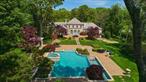 Magnificent Brick Colonial in Prestigious Old Brookville tucked away on a private cul-de-sac in one of Long Islandâ€™s most exclusive enclaves, this stately brick Colonial embodies timeless elegance and refined indoor-outdoor living. Designed with an eye for classic proportions and luxury detail, the 8, 500-square-foot residence is crowned with a slate roof and surrounded by manicured, park-like grounds spanning two landscaped acres. A tree-lined courtyard framed by evergreens and flowering trees sets the stage for grandeur. Double entry doors lead to a dramatic circular marble foyer with a gold-leaf domed ceiling. A sweeping curvilinear staircase ascends to the second level, while the light-filled main rooms overlook the spectacular property. The gracious living room, ideal for entertaining, features a custom wood built-in bar, a dramatic mantled fireplace, and three sets of French doors with Palladian windows opening to the gardens. The formal dining room with a round table is capable of seating 12 and is finished in Venetian plaster and highlighted by a luxurious gilded domed gold-leafed ceiling. The open-concept kitchen and adjacent family room offer an inviting space for everyday living and gatherings, complete with a beamed cathedral ceiling and seamless access to the expansive brick patio, gardens, outdoor bar, and a resort-style swimming pool with built-in hot tub and cascading waterfalls. The luxurious main-level primary suite is privately situated in its own wing, accessed via a long hallway. It features expansive fitted closets, a marble bath, and a private staircase to the homeâ€™s wellness center with steam room, sauna, two full baths, and direct pool access. A flexible adjoining bedroom suite with a full bath can serve as an office, nursery, or sitting room with fireplace. A powder room, service wing with half bath, laundry room, and a second staircase to the lower level complete the main floor. Upstairs, four generously sized bedrooms, three full bathrooms, and a large cedar closet room offer ample space for family and guests. The fully finished walk-out lower level enhances the homeâ€™s lifestyle offering with a large recreation room, a ballet/yoga studio with mirrored wall and barre, a built-in bar, and a full spa experience including a sauna, steam room, and additional bathroomsâ€”ideal for massage or fitness routines. The two acre grounds are as exceptional as the home itself, showcasing an in-ground pool, mature trees and plantings, expansive multi-level brick patios, and a portico with a wet barâ€”perfect for hosting unforgettable events or enjoying tranquil days at home.