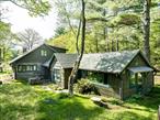 A spectacular view of Bass Meadow and mountains is just one of the highpoints of this beautiful Cape Cod home on 6.1 acres located a few miles from Woodstock Village. From the home&rsquo;s wraparound stone patio and large windows, imagine looking out at a serene 70-acre vista of meadow and woods that is protected from development. This lovely, turnkey 2209-square-foot home features an open-plan living area with a kitchen, dining area, den, and comfortable living room anchored by a stone fireplace. Everywhere you look, there are stunning views. The second floor is no exception. A center staircase leads to two bedrooms with skylights and a full bath complete with a custom tub and newly renovated shower. A small area beside the staircase could serve as a reading nook or put to creative use. Downstairs, the den has the potential to be transformed into another bedroom or could become a convenient playroom or workspace. Glass doors let in more light and provide access to the stone patio. A second full bathroom is located on the first level. From the kitchen/foyer, a door leads to a breezeway, garage, and spacious heated office/studio with windows facing the meadow and mountains. This great private space away from the main house could remain an office/studio or be converted to an extra bedroom. Step outside, and you&rsquo;ll see a building across the driveway that was once the Lake Hill firehouse. This vintage structure could be reimagined as a guest house or office/studio. Or it could make a terrific home gallery or music studio. The incredible views of Bass Meadow and mountains are sure to provide endless inspiration. Whether enjoyed as a year-round home or weekend retreat, 11 Louie Way is a 10-minute drive to the heart of vibrant Woodstock, famous for its cafes, boutiques, galleries, and music venues. Phoenicia, Saugerties, and Kingston are also nearby for shopping, dining, and entertainment.