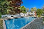Welcome to your own private paradise in the heart of Quogue! Nestled on over an acre of lush, wooded grounds, this timeless Hamptons hideaway offers the ultimate blend of serenity, space, and seasonal enjoyment.This architecturally distinct 4-bedroom, 3-bath Modern Contemporary residence is bathed in natural light and surrounded by pristine landscaping, providing total privacy and a seamless connection to nature. Inside, clean lines, skylights, and expansive windows create a breezy, modern ambience. The classic Chefs-style kitchen evokes retro charm, while the spacious bedroomsâ€”including a sun-drenched primary suite with pool viewsâ€”offer effortless comfort.Step outdoors and discover a lifestyle most only dream of: serve up matches on your private tennis court, unwind poolside on the sprawling deck, or take a sunset soak in the heated pool nestled amongst colorful gardens.Located just moments from Quogue Village, Main Street shops, and world-renowned Quogue Village Beach, this property is an ideal opportunity to embrace true Hamptons livingâ€”private, peaceful, and filled with unlimited potential.A rare and refined offering in one of the most coveted enclaves in the Hamptons.