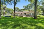 This stunning expanded ranch in the heart of Mattituck offers breathtaking views of Peconic Bay and is just a short distance from its gorgeous private deeded beach. Boasting over 2, 600 square feet of living space, the home is perfectly situated on two-thirds of an acre. Upon entering, you&rsquo;ll find a welcoming front deck that leads into a bright foyer showcasing an open floor plan. This area is anchored by a double-sided, stacked white stone gas fireplace, creating a cozy yet stylish atmosphere. Comfortable lounge seating and a charming dining area are filled with natural light and feature beautiful wood floors. The custom kitchen is adorned with granite countertops, custom cabinetry, stainless steel appliances, and a center island with seating, making hosting and entertaining a breeze. An expansion has added a spacious great room designed with a vaulted ceiling and radiant flooring. The oversized focal point window captures the bold blue water views, while glass partition track sliding panels allow the main rooms to be opened up for larger gatherings or closed off for more intimate settings. The great room also features open stairs that lead to a finished lower level, which can serve as a media room or game room, complete with a new bathroom and additional storage space. A breezeway leads to the north wing of the home, beginning with a separate laundry area and flowing into the primary ensuite bedroom, which includes double closets and a spa-inspired bathroom. Down the hallway, three additional bedrooms share access to a newly renovated bathroom. Outdoor living is equally impressive with a beautifully crafted rear mahogany deck perfect for al fresco dining, a lower-level patio with a fire pit, and a spacious lawn ideal for relaxing with a hammock or designing a pool. The property also includes a separate outdoor remote workspace, an enclosed garden with irrigation for gardening enthusiasts, and an oversized driveway with a detached two-car garage. The vibrant hamlet is conveniently located near vineyards, farm stands, the renowned Love Lane for local shopping, and Veterans Beach.