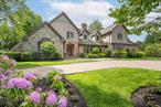 This stately custom-built home offers 5 bedrooms and 4.55 baths, set on a beautifully landscaped shy 1-acre lot. Boasting over 6, 000 square feet of elegant living space, this residence seamlessly blends grandeur with comfort.Step into the impressive foyer featuring radiant heated marble floors, a sweeping grand staircase, and soaring cathedral ceilings. The main level includes a formal living room with fireplace, a sophisticated library with fireplace, and a banquet-sized dining room ideal for entertaining. The chefâ€™s kitchen, equipped with top-of-the-line appliances, opens to an expansive family room with fireplace, vaulted ceilings, and French doors leading to your private backyard oasis. A first-floor guest suite offers a full bath, sitting area, and private entranceâ€”perfect for visitors or extended stays.Upstairs, the luxurious primary suite is a true retreat, featuring a spa-like bath with steam shower, claw foot tub, a generous dressing room, and a spacious oversized walk-in closet. Three additional bedrooms complete the second floorâ€”one with an en-suite bath and two sharing a hall bath.The resort-style backyard is an entertainerâ€™s dream with a heated saltwater in-ground pool, built-in BBQ, lush specimen plantings, and multiple entertaining areasâ€”all designed for relaxing and enjoying outdoor living in style.