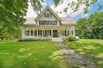 The House on the Hill Proudly offered for the first time in over 70 years. This expansive and character-rich home overlooks the heart of the village while offering nearly 10 acres of space, privacy, and endless potential. Set across three separate parcels totaling 9.68 acres, the property features a main house with approximately 4, 000 sq ft, a charming 2-bedroom guest cottage, a large dairy barn, and multiple additional outbuildingsâ€”perfect for storage, hobbies, or future repurposing. The main residence is a classic 4-bedroom, 2.5-bath old-style home, full of original details and thoughtful design. From the moment you step onto the covered front porch, youâ€™re greeted with panoramic views and a sense of timeless charm. Inside, the first floor offers high ceilings, hardwood floors, a wood-burning fireplace, multiple living rooms, and an eat-in kitchen with space to gather. Two separate staircases lead upstairs to four bedrooms and two full bathrooms, along with a bonus space. A walk-up third floor includes two additional rooms that can serve as offices, playrooms, or guest quarters. The walk-out basement features a second fireplace, a built-in bar, and direct access to a sunken courtyardâ€”a unique and private setting for entertaining or relaxing outdoors. The guest cottage is ideal for extended family, visitors, or rental income, offering 2 bedrooms, 1 full bath, and its own private space away from the main home. Outside, the sprawling front lawn, mature trees, and open acreage provide both seclusion and a sense of grandeur. Whether you&rsquo;re dreaming of a small farm, multigenerational living, or simply a private escape with room to grow, this property is a rare find with deep roots and lasting appeal. Conveniently located just minutes from shops, schools, parks, and major commuter routes, this is an incredible opportunity to own a storied piece of Chester historyâ€”with the space and structure to shape your future.