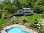 Privately sited on a quiet back road in the Catskills, Noorden House is a modern retreat offering both seclusion and convenienceâ€”just 20 minutes to Woodstock, 15 to Phoenicia, and 30 to two ski mountains. Elevated on over 5 acres, the home enjoys distant mountain views, beautifully landscaped grounds, and serene natural features including a heated freeform pool, a small pond, and a picturesque creek that winds through the woods. The architecture emphasizes light and flow. Expansive windows and sliding glass doors let sunshine pour into the living spaces, highlighting exposed beams and warm wood accents. The wraparound deck is ideal for dining, lounging, and enjoying the peaceful setting, with views over the pool and gardens. Inside, the main living area opens into a cozy dining space with a gas fireplace and wood-beamed ceiling. The adjacent kitchen is well-designed and functional, with a generous island, ample cabinetry, and a walk-in pantry. A main-level office/guest room and a combined laundry/powder room complete this floor. Upstairs, a central lounge anchors three bedrooms, including a vaulted-ceiling primary suite with exposed beams and a bright modern bath with glass-enclosed shower. Two additional bedroomsâ€”one full and one with twin beds and a charming lofted third bedâ€”share a bathroom with double sinks and a soaking tub. The finished lower level includes a recreation room with ping-pong table, a massive chalkboard wall for creative fun, a full bath, and French doors that lead directly outdoorsâ€”perfect for post-swim use. Beyond the home, the grounds are a highlight: a fire pit for evenings under the stars, a peaceful pond that draws wildlife, and a wandering creek that invites quiet exploration. Whether lounging poolside or wandering the woods, the property offers a deep sense of calm and connection to nature. Located in the heart of the Catskills, Noorden House is close to hiking trails, the Esopus Creek, local galleries, and farm-to-table dining. The Kenneth L. Wilson Campground is just minutes away for kayaking, paddleboarding, and fishing. In winter, enjoy nearby skiing at Belleayre and Hunter Mountains, both 30 minutes away. This is a thoughtfully designed, turn-key escape with space to relax, entertain, and rechargeâ€”indoors and out.
