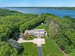LAUREL HOLLOW. Tucked away in the serene heart of Laurel Hollow, this custom cedar shake and stone estate offers the rare combination of privacy, elegance, and refined designâ€”set on over 2.7 acres of beautifully landscaped grounds with peaceful seasonal water views. Originally part of the historic grounds that once belonged to Laurelton Hall, the storied 580-acre estate of Louis Comfort Tiffany, this home carries with it a quiet legacy of artistry and craftsmanshipâ€”reimagined for modern living. Step inside to a warm and inviting central foyer, where soft natural light and architectural detailing create a sense of welcome and balance. Thoughtfully designed, the first floor unfolds in four distinct directions: toward the sun-drenched living room and sunroom, a richly appointed formal dining room, the heart of the home in the chefâ€™s kitchen, and the expansive yet intimate family roomâ€”each space seamlessly connected and beautifully finished. Featuring 6 bedrooms and 5.5 bathrooms, the home is adorned with custom millwork, bespoke built-ins, high-end finishes, and curated details throughout, creating a harmonious blend of character and comfort. Outdoors, the setting is equally impressiveâ€”with lush lawns, mature trees, and glimpses of Cold Spring Harbor in the distance. Residents enjoy beach and mooring rights, proximity to charming village shops and fine dining, prestigious yacht and country clubs, and convenient access to the Long Island Railroad. This is more than a homeâ€”itâ€™s a retreat, a legacy, and a lifestyle waiting to unfold.