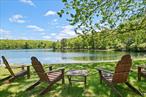 Located in the highly sought-after community of Wolf Lake, this expansive lakefront property offers a rare blend of privacy, space, and water access set on almost one acre across two combined waterfront lots with approximately 150 feet of frontage on Division Pond.The home features two private suites each with walk-in closets, en-suite baths, and direct access to a deck or balcony with water views. Two bathrooms have been recently renovated, adding comfort and modern style.The main level offers an eat-in kitchen with generous counter space, a formal dining room, a dedicated office and a reading room, a spacious primary suite, a cozy sitting area with wood-burning fireplace, living room with direct access to the deck and screened-in porch overlooking the water.Upstairs, a second suite with elevated water views, along with additional bedrooms, a reading nook, and a kitchenette with separate entrance; ideal for guests or extended stays.The walk-out basement includes a large recreation room with fireplace, wet bar, and pool table, plus a potterâ€™s studio, laundry room, new boiler with new double-walled oil tank, and workshop. Also take note of the whole home generator so you can rest assured and uninterrupted regardless of what mother-nature has in mind. A screened-in patio off the basement offers serene outdoor space steps from the water.This is a rare opportunity to own a full-acre, double-lot lakefront home in Wolf Lake. Perfect for year-round living, multigenerational use, or a four-season retreat. Wolf Lake features 1, 800 private acres of untouched forestland, miles of maintained hiking trails, member access to three spring-fed lakes, and a clubhouse with a full calendar of events. Just 90 minutes from the George Washington Bridge, this is one of the Hudson Valleyâ€™s most coveted lake communities. One-time Wolf Lake membership fee: $5, 250. Annual dues: $1, 200.