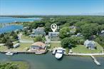 Step into a world of endless summer at this quintessential Nantucket-style cedar shake home, perfectly sited with expansive views of the Peconic bay and Corey creek. With its charming Dutch doors and expansive upper and lower decks, youâ€™ll be invited to soak in the refreshing sea breezes and panoramic waterside vistas along with views of your private dock across the street, deep enough for a 66â€™ boat. A waterside storage shed keeps all of your water toys, from paddle boards to kayaks, within easy reach and protected. Inside, the open floor plan connects a gourmet kitchen to a cozy living room with a built-in wet bar, all overlooking the water. Originally designed as a main floor Mastersuite, the homeâ€™s addition now serves as a golf simulator room, adding a playful twist to luxury living. Upstairs offers another Mastersuite option as well as 2 additional bedrooms, laundry, plenty of storage, and a full bath. For those moments when you seek tranquility, multiple decks, patios, and a private man-made beach on Corey Creek offer serene spots to unwind. Alternatively, the natural beach of the Laughing Waters homeowners association on the bay provides an idyllic setting for relaxation, where the sounds of the residents laughing epitomize the joyous community spirit. This property is not just a home; it&rsquo;s a lifestyle, where every day feels like summer camp. Perfect for those who cherish waterfront living, active recreation, and the simple joys of nature, 2335 & 2480 Minnehaha Blvd is a dream come true. Don&rsquo;t miss the chance to make this enchanting retreat your own and create memories that will last a lifetime.