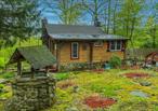 Do you dream of mountain living? Tucked among lush greenery, this 2-bed, 1-bath home offers one of the most private properties in Mountain Lodge Park with .73 of an acre of idyllic land and a second usable structure! The interior features a high ceiling in the living room, which can be overlooked by a loft off one of the bedrooms; a recently refreshed bathroom; and an enclosed porch to enjoy year-round. True to its rustic form, this home is sure to give you your own cozy, personal retreat. Basement access is convenient for your laundry and storage needs, and has an additional space with great transformational potential that allows you to walk right into the backyard. Outside, immerse yourself in the storybook yard. Meander down pathways, wander across miniature bridges, sit around the fireplace and pass beneath an archway to the second structure. When youâ€™re not roaming the grounds, overlook the natural magic of your surroundings from the deck. The second structure is connected to electricity and can be connected to water, providing endless possibilities! With so much character, charm and potential, this is the perfect setting for your mountainside sanctuary. Selling as-is.