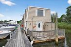 Discover your dream waterfront retreat at this stunning two-story boathouse situated along the picturesque Peconic River. This charming property features two cozy bedrooms and a thoughtfully designed bath equipped with a modern composting toilet. The full kitchen is a chef&rsquo;s delight, boasting a convection countertop oven, ice maker, propane stove, and refrigerator, with all essential plates, cups, utensils, pots, pans, and a delightful dinette set included. Enjoy the convenience of an in-unit washer and dryer.Relax in style with one furnished bedroom and the comfort of two mini splits for heating and air conditioning. Stay connected with free WiFi throughout the property. For boating enthusiasts, boat slips are available, allowing you to live the waterfront lifestyle year-roundâ€”where you can fish, immerse yourself in the sounds of nature, and wake up to breathtaking sunrises. Unwind at sunset on one of the three spacious decks, taking in the serene surroundings that make this home truly special.Conveniently located just 4 miles from the Tanger Outlets and close to downtown Riverhead, you&rsquo;ll have easy access to fantastic restaurants, shopping, the Long Island Aquarium, and a wealth of local attractions. This is a cash-only opportunity, so seize the chance to own a piece of paradise on the water today!