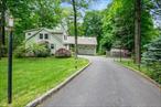 Welcome to 26 Mayberry Road, a charming and spacious 5-bedroom expanded ranch-style home on a quiet cul-de-sac street in the Chappaqua school district. Set on a private, landscaped acre, this home offers scenic views from the elevated deck and large stone patio just off the walkout lower level. The main floor features a versatile and inviting layout with formal living and dining rooms, a kitchen open to the breakfast area, and a family room featuring a wood-burning fireplace with heat insert, skylight, and stairs up to a bonus/playroom over the garage. The family room has direct access to a fully enclosed 3-season sunroom and upper deck with stairs down to the stone patio below. The first floor also includes the primary bedroom with an en-suite bathroom, a home office, and an additional full bathroom. Upstairs, there are four generously sized bedrooms and a full bathroom. The walkout lower level has a sliding glass door to the patio and includes an additional 900 square feet of finished storage, a dedicated laundry room, and plenty of utility/storage areas.